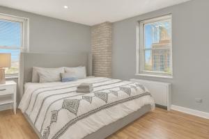 a bedroom with a large bed and two windows at Atlanta Downtown Escape Walk Everywhere in Atlanta