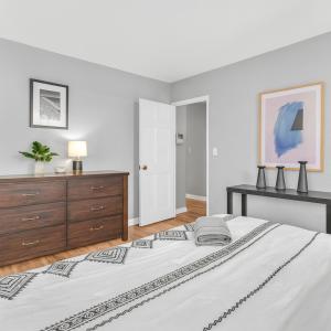 a white bedroom with a large bed and a dresser at Atlanta Downtown Escape Walk Everywhere in Atlanta