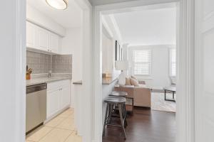 eine Küche mit weißen Schränken und ein Wohnzimmer in der Unterkunft Downtown 1br Condo Walk To Stadium & Aquarium in Atlanta + 8 Fotos