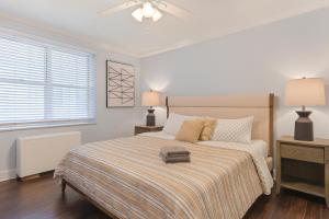 ein weißes Schlafzimmer mit einem Bett mit einer gestreiften Decke in der Unterkunft Downtown 1br Condo Walk To Stadium & Aquarium in Atlanta