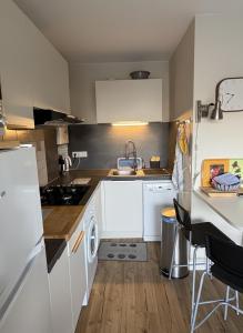 Una cocina con gabinetes blancos y un fregadero. en Charmant appartement au Moulleau, en Arcachon