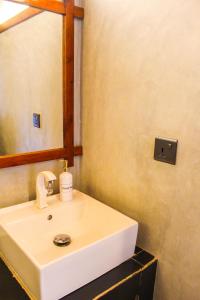 een badkamer met een witte wastafel en een spiegel bij Ella Mc Queen Homestay in Ella +52 foto's