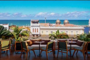a patio with a table and chairs and the ocean at Motto By Hilton Recife in Recife