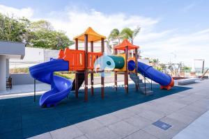 a playground with a slide on a roof at Apto em condomínio Pé na areia 3 Quartos Cozinha Completa Sacada com Churrasqueira Vaga de Garagem Piscina borda infinita Academia Quadra de esportes Sala de Jogos Summer Home Club acesso direto a praia in Piçarras