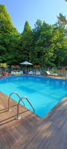 una gran piscina azul con sillas y sombrilla en HOTEL ARIMANNIA Depandance, en Caramanico Terme
