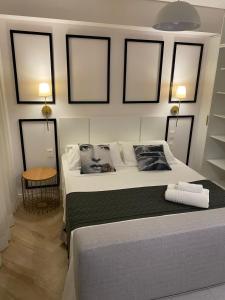 a bedroom with a bed with four pictures on the wall at Studio Lucas By Yoo Luxo in Porto Alegre