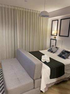 a bedroom with a bed with two towels on it at Studio Lucas By Yoo Luxo in Porto Alegre