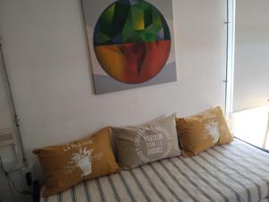 a couch with two pillows and a painting on the wall at Sueño Dorado Container in Chapadmalal