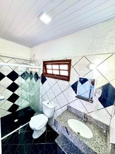 a bathroom with a toilet and a sink at Pousada Maravista in Cananéia