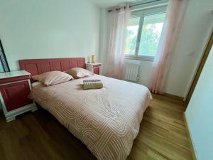 トゥーロンにあるPerle rare, F4 donnant sur un grand jardin privé aménagé, parkings gratuits, clim, calme, idéal famille & pro, 10 min de la mer et du centre-ville, de la gare sncf et routièreの大きなベッドと大きな窓のある寝室