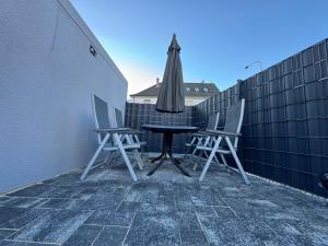 a table and chairs on a balcony with an umbrella at Sunshine in Groß-Zimmern