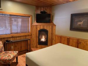 een kamer met een open haard, een televisie en een bed bij Timberline Lodge - Arnold - Bear Valley - Murphys in Arnold