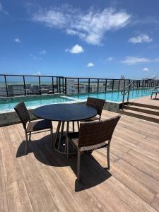 uma mesa e cadeiras num deque com água em Move Tambau 108 em Tambaú