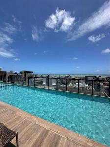 uma piscina com vista para a praia em Move Tambau 108 em Tambaú