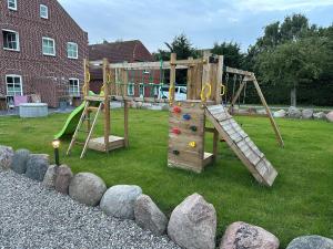 a wooden playground with a ladder and a slide at Linnebarg Hus 1 in Bisdorf