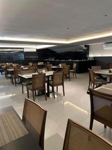 uma sala de jantar cheia de mesas e cadeiras em Move Tambau 108 em Tambaú