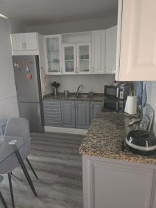 Una cocina con gabinetes blancos y encimera. en Apartamento Ana en Playa de Santiago, en Playa de Santiago