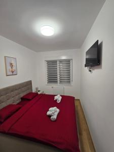 a bedroom with a red bed with towels on it at Dana in Banja Luka