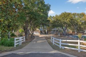 a white fence next to a sidewalk with trees at Luxury Golf Course Private Retreat with Heated Swimming Pool in Horseshoe Bay