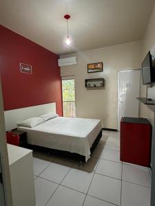 a bedroom with a bed and a red wall at Hotel Império Santarém in Santarém +33 photos