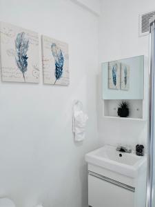 a bathroom with a white sink and a white toilet at Center of everything, art, beach and culture in santurce in San Juan