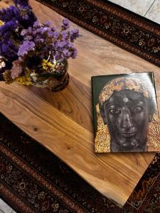 a table with a portrait of a head and a vase of flowers at MetsoVillas στο κέντρο του Μετσόβου in Metsovo +24 photos