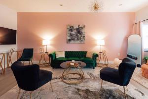 a living room with a green couch and chairs at Cozy Loft in Downtown Johnson City in Johnson City