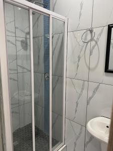 a bathroom with a shower and a toilet and a sink at The Palms Guest House in Johannesburg