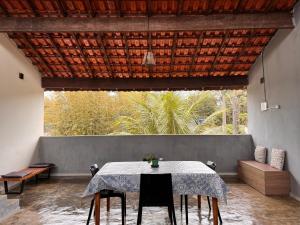 a dining room with a table and a large window at Chalé com Varanda Grande e Terraço Vista Mar in Itanhaém