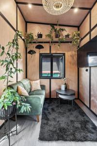 a living room with a couch and a table at Tiny Home Escape w Sauna and Plunge in Whangarei