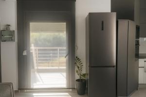a kitchen with a refrigerator and a door to a balcony at Sountou home in Xanthi