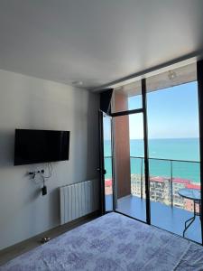 une pièce avec une télévision à écran plat sur un mur dans l'établissement NBG Aparthotel, à Batoumi