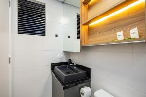 une salle de bain avec un lavabo et des toilettes dans l'établissement Edificio Heart Urban Habitat, à Curitiba 27 autres photos