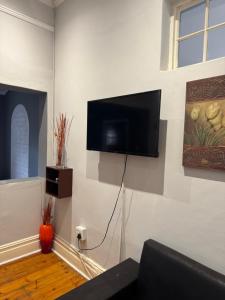 a living room with a flat screen tv on a wall at Eagles Enest BnB in Pietermaritzburg +35 photos