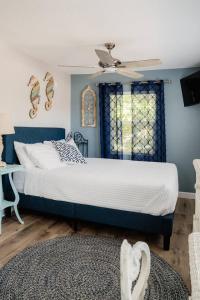 a bedroom with a bed with blue walls and a ceiling at Cozy Coastal Cottages of Dunedin 4 in Dunedin