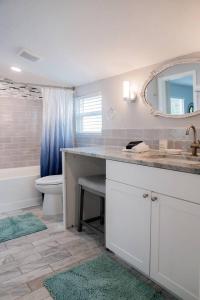 a bathroom with a sink and a toilet and a mirror at Cozy Coastal Cottages of Dunedin 4 in Dunedin +40 photos