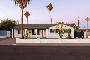 斯科茨Blush Bungalow的一座白色的房子，前面有棕榈树