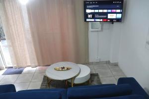 a living room with a table and a tv at Optimum Stay Self Catering Accommodation - Deluxe Room in Cape Town +30 photos