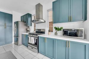 a kitchen with blue cabinets and a stove and refrigerator at Luxury Mansion with Chefs Kitchen by Niagara Falls in Thorold +24 photos