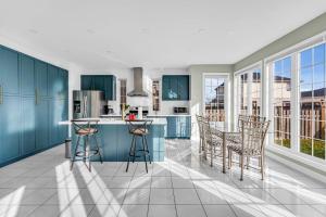 a kitchen with blue cabinets and a table and chairs at Luxury Mansion with Chefs Kitchen by Niagara Falls in Thorold