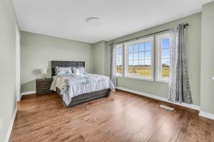 a bedroom with a bed and a large window at Luxury Mansion with Chefs Kitchen by Niagara Falls in Thorold