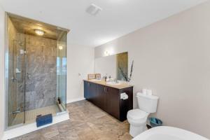 a bathroom with a shower and a toilet and a sink at Luxury Home Mins from Waterfall next to Transit in Niagara Falls