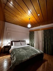 a bedroom with a large bed with a wooden ceiling at MetsoVillas στο κέντρο του Μετσόβου in Metsovo