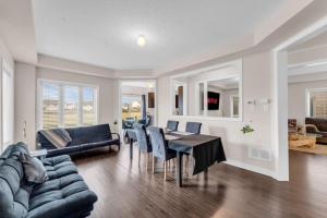 a dining room and living room with a table and chairs at Luxury Home Mins from Waterfall next to Transit in Niagara Falls