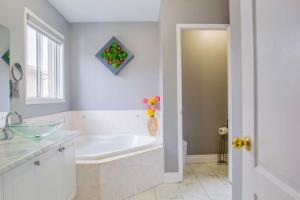 Un baño blanco con bañera y lavabo. en Royal Luxury Central Home with Gazebo By Toronto, en Brampton