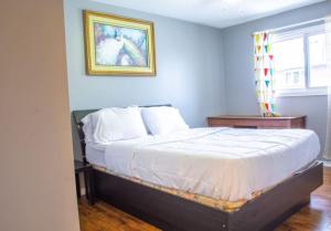 Un dormitorio con una cama con un cuadro en la pared. en Royal Luxury Central Home with Gazebo By Toronto, en Brampton