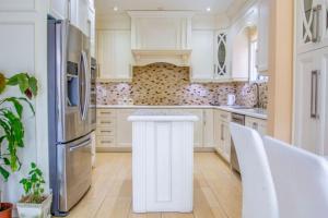 Una cocina con gabinetes blancos y un refrigerador blanco. en Royal Luxury Central Home with Gazebo By Toronto, en Brampton 18 fotos más