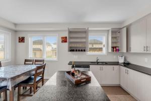 eine Küche mit Tisch und ein Esszimmer in der Unterkunft Bright and Stylish Family Home Near Niagara Falls in Thorold