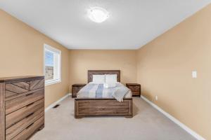ein Schlafzimmer mit einem Bett und einem Fenster in der Unterkunft Bright and Stylish Family Home Near Niagara Falls in Thorold