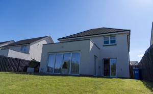 a white house with large windows and a fence at Ardlui House Gardens in High Blantyre +3 photos